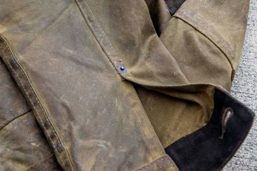 The tin cloth fabric both darkens and smooths out on areas of high abrasion (elbows, cuffs)